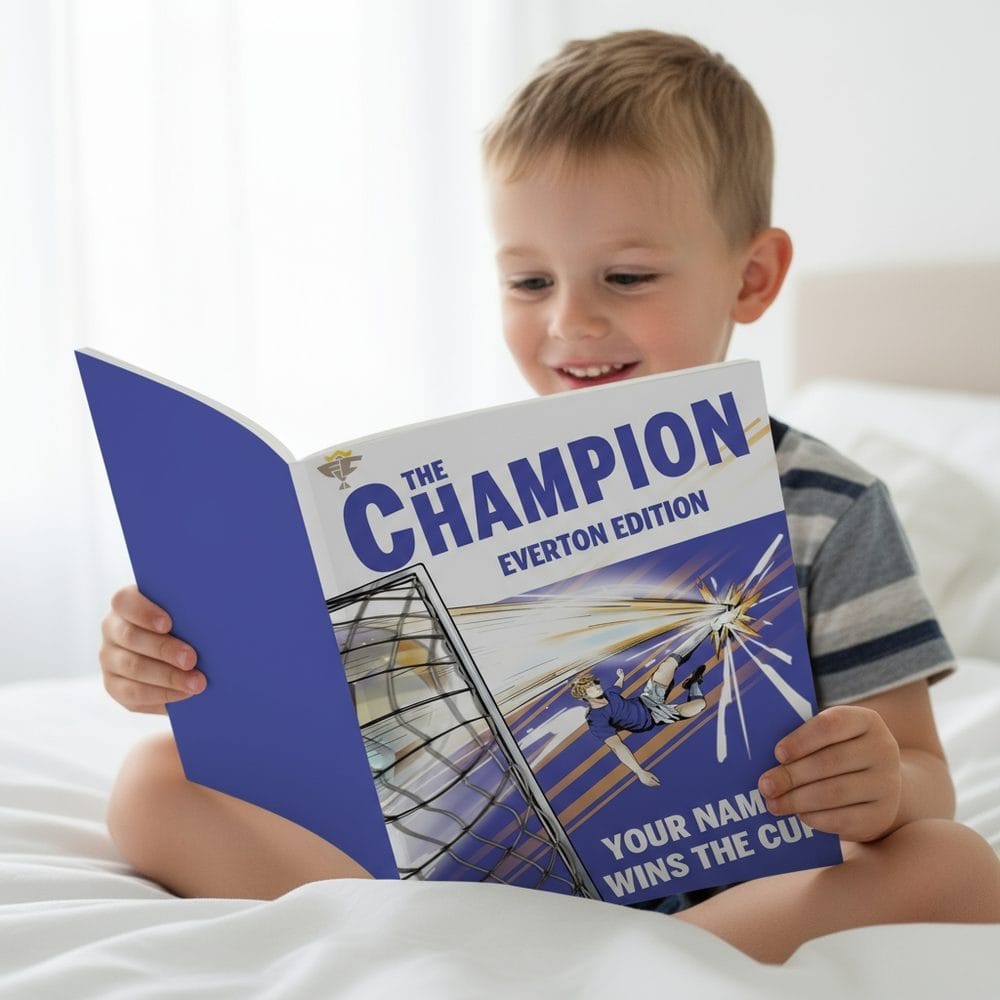 A young boy sitting on his bed reading his personalised Everton Champion storybook